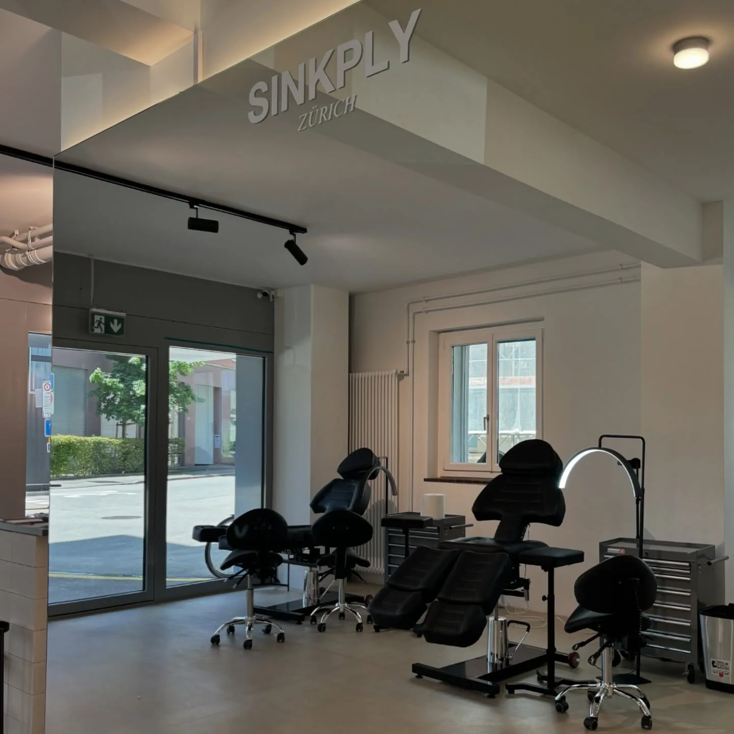 Inside Sinkply Zürich — tattoo stations under the studio sign